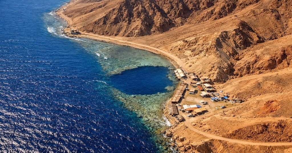 Vista aerea del Blue Hole Buco Blu di Dahab con barriera corallina e acque turchesi nel Mar Rosso