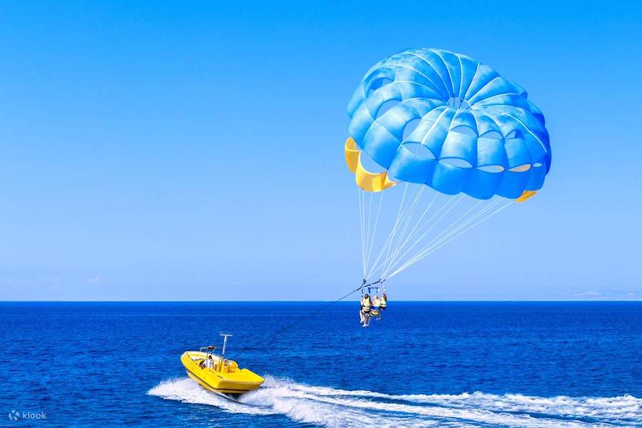 Barca del parasailing con paracadute in volo sopra le acque cristalline di Sharm El Sheikh.