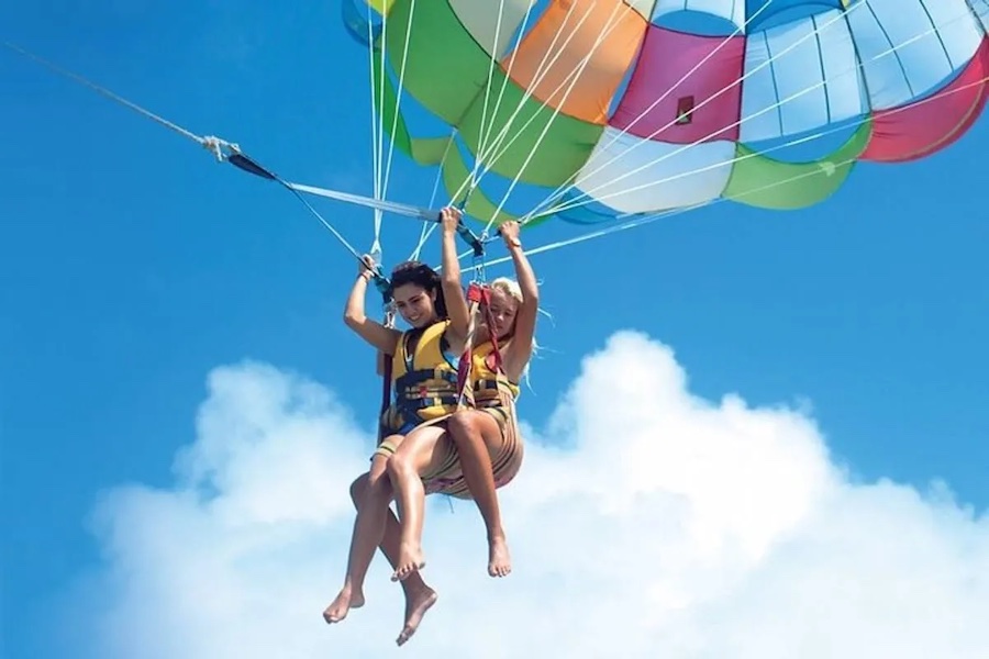 Barca del parasailing con paracadute in volo sopra le acque cristalline di Sharm El Sheikh.