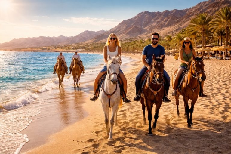 Tour a Cavallo a Sharm El Sheikh lungo la riva del Mar Rosso con cavalieri sulla spiaggia e montagne del Sinai sullo sfondo