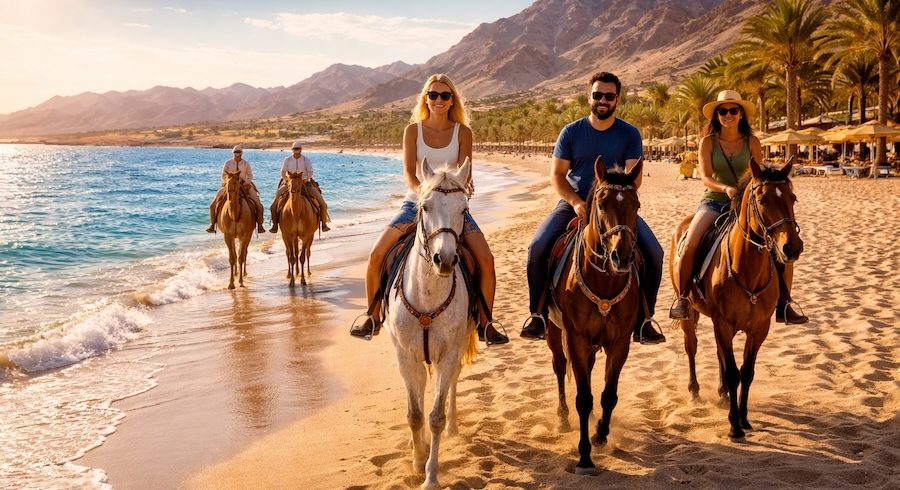 Tour a Cavallo a Sharm El Sheikh lungo la riva del Mar Rosso con cavalieri sulla spiaggia e montagne del Sinai sullo sfondo